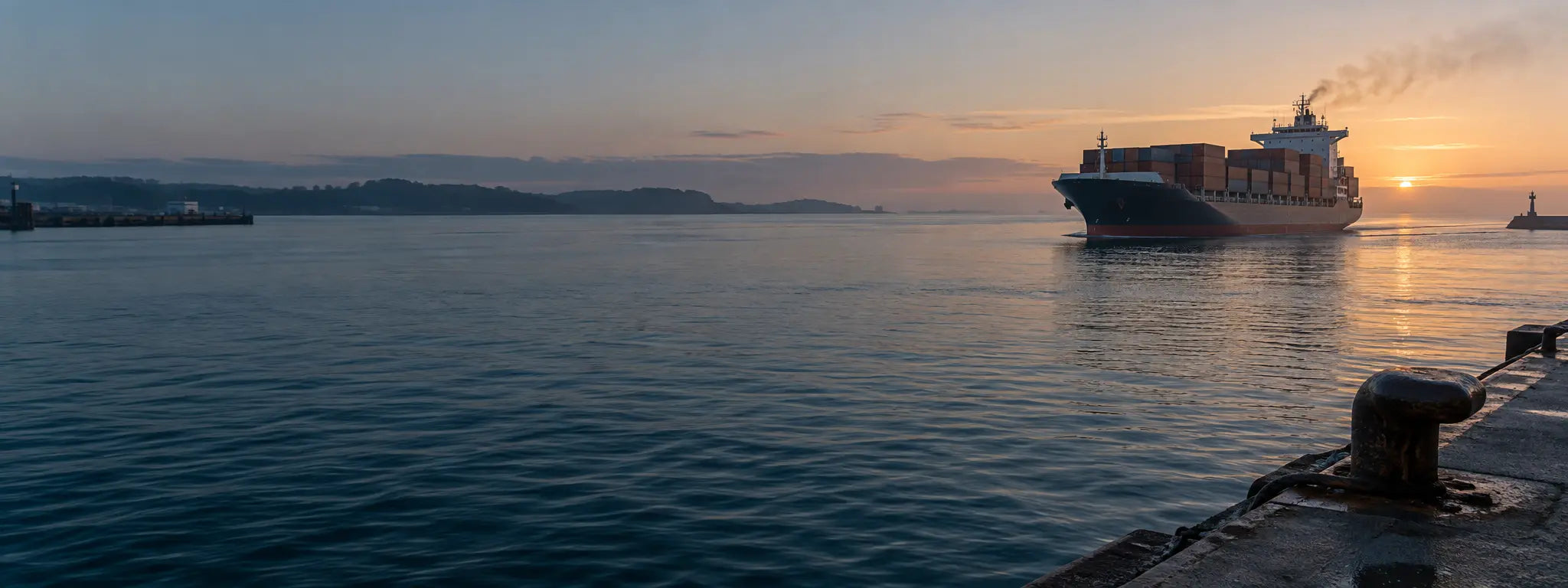 Cargo vessel departing a harbor at dawn